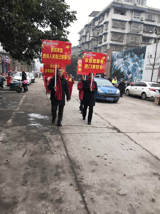 信用社员工举牌并邀请腰鼓队游街宣传_副本.jpg