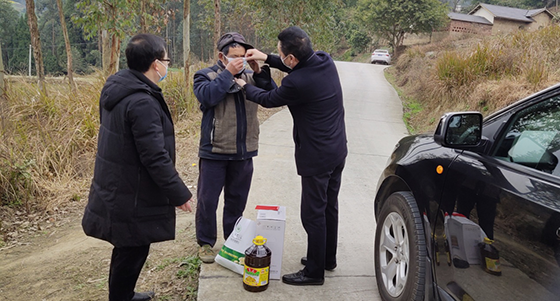 图为刘阳德书记向帮扶户付运才送防疫物资并亲自教其戴口罩.png