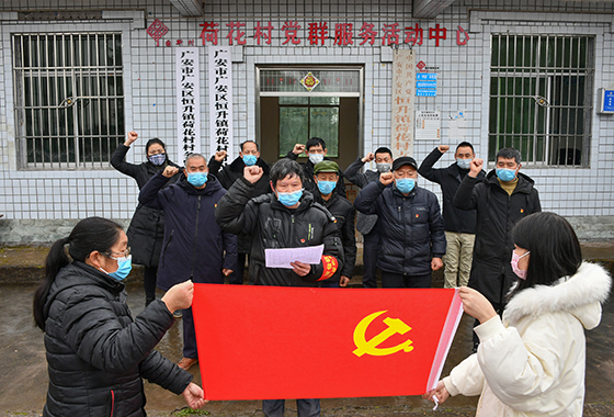 在疫情防控的关键时刻，2月4日，在入村劝导点前，四川省广安市广安区恒升镇荷花村支部书记刘延春与全体党员在鲜红的党旗前庄严宣誓  张国盛摄.JPG