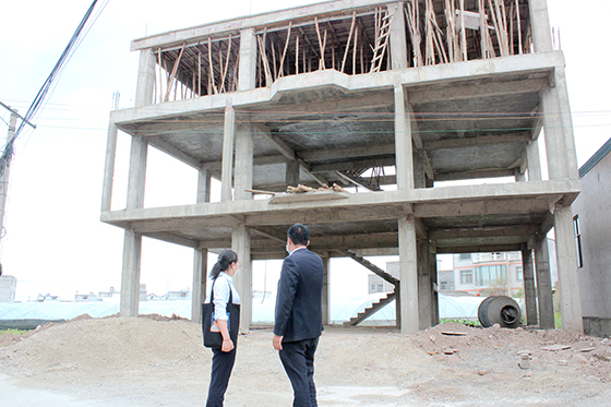 客户经理实地了解村民即将落成的自建房.JPG