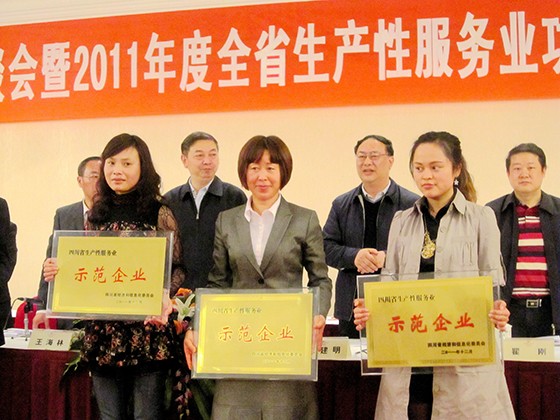 西昌金信村镇银行董事长梁文英(中)上台接受“四川省生产性服务业示范企业”牌匾.jpg