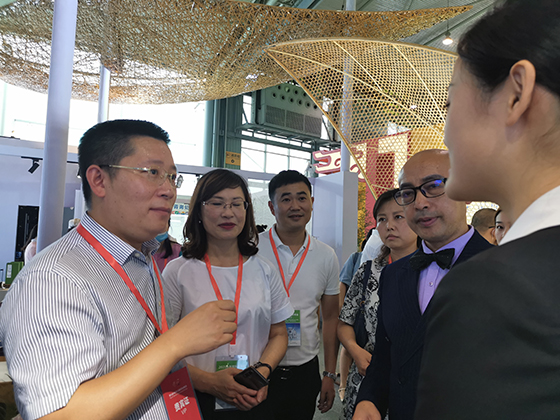 崇州市副市长郑文学（左）与茶博会参会嘉宾交流  周淼葭 摄.jpg