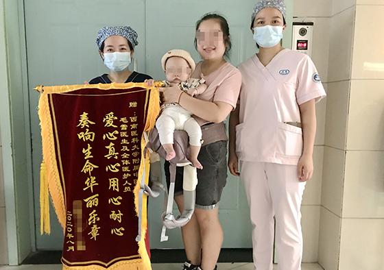 怀抱宝宝洋溢着幸福的张女士给新生儿科送来锦旗.jpg
