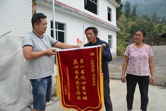 张远银送锦旗给驻村第一书记李建荣  吴启昌 摄.jpg