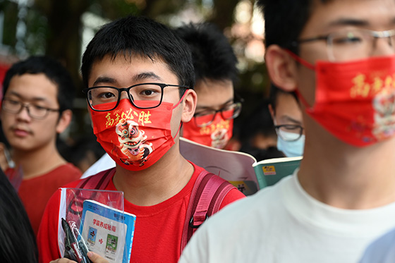 2)2022年6月7日，在全国普通高校招生考试四川省内江市第六中学考点外，考生戴着“高考必胜”和“金榜题名”等字样的口罩准备进入考场.jpg