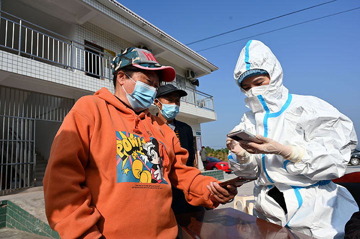 1)11月19日，内江市东兴区永兴镇莲花村第一书记、村干部和志愿者正在为核酸采集村民扫码登记信息.jpg