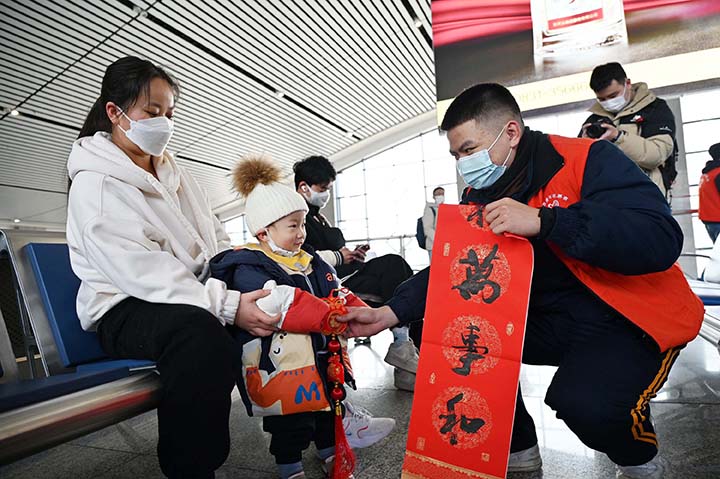 2志愿者为旅客送上具有浓郁年味特色的“福”礼.jpg