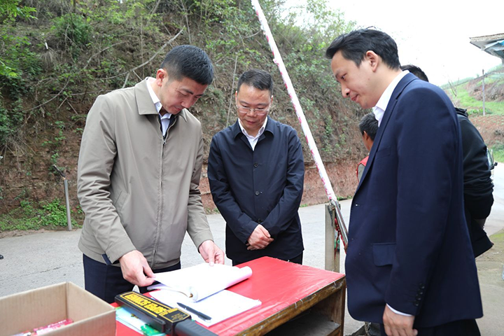 1县委书记肖刚（左）带队来到云锦镇桂花村，查看《进入林区人员登记表》，调研督查森林防灭火工作开展情况.png