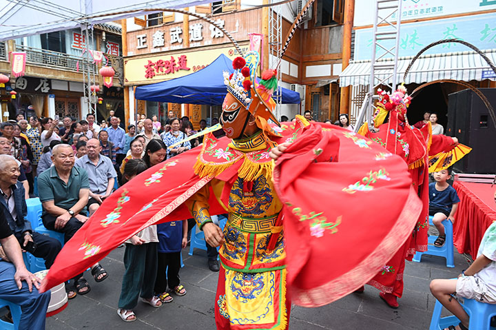 图2  2023年6月22日，在四川省内江市东兴区东兴老街，川剧演员为观众表演“变脸”。.jpg