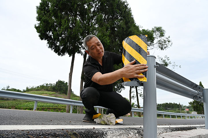 图3  筑路工人正在加紧校正同福至新官山沥青混凝土公路的安防设施.jpg