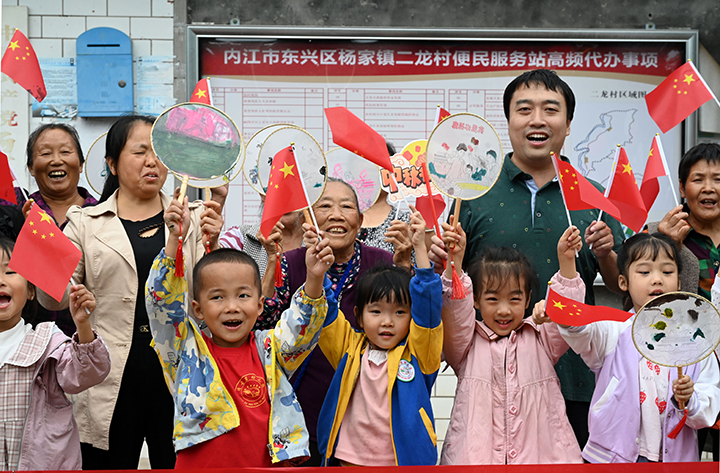 图4  村里的老人和小孩挥舞着五星红旗和自己亲手绘制的团扇作品喜迎“双节”.png