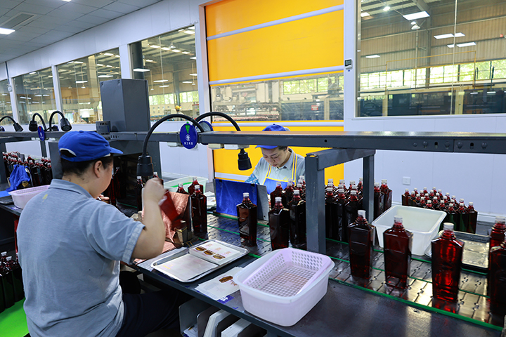 3工人给生产出来的酒瓶进行擦拭并贴上标签  周淼葭 摄.JPG