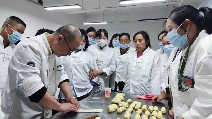 图5 “桑工巧匠”灵活就业培训基地内，老师向学员演示糕点制作技巧.jpg