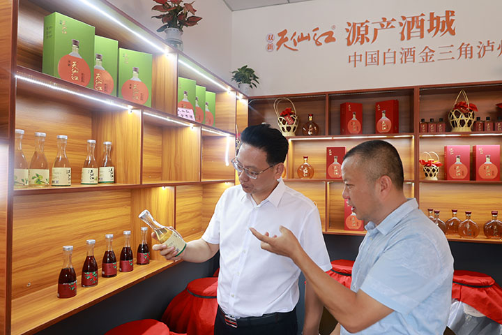 4李强（右）介绍双新村生产的产品.jpg