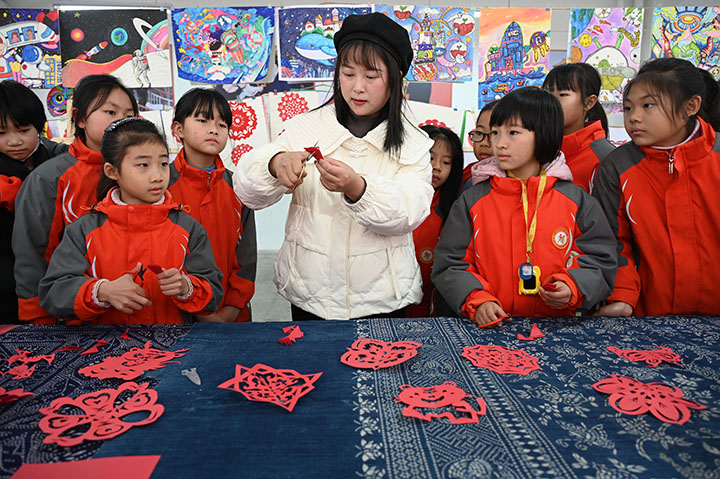 图1  2024年1月5日，在四川省内江市东兴区牛牦山小学校，剪纸兴趣班的学生正在老师指导下学习剪纸。.jpg