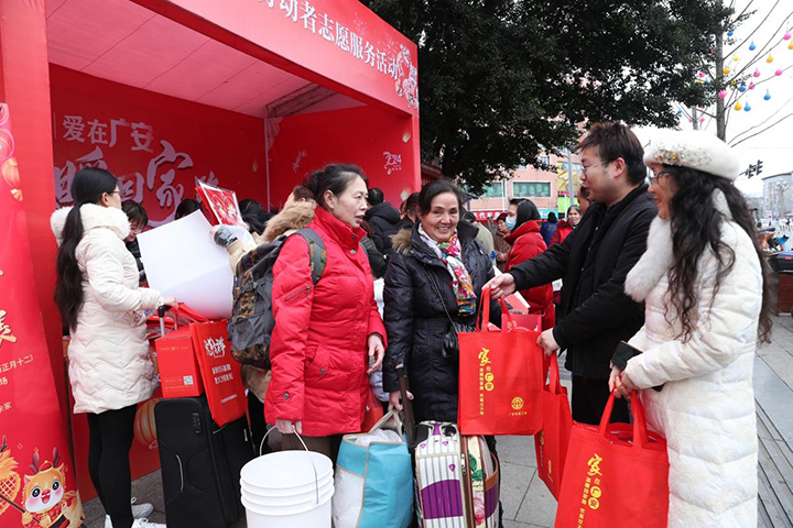 图１广安区总工会和农民工服务中心的志愿者正在向返乡劳动者赠送春节大礼包.jpg