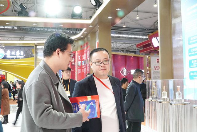 4 参展观众和工作人员洽谈经销事宜.jpg