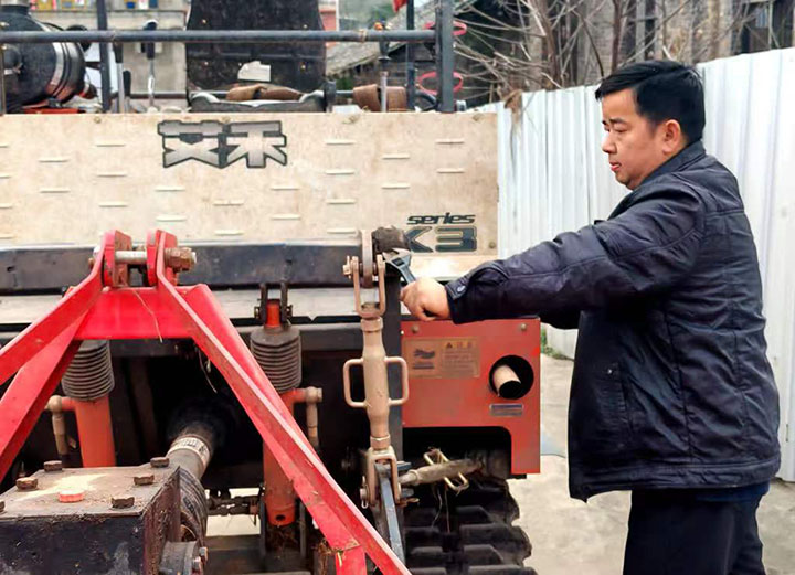 图1  陈仁见正在对农机进行维护.jpg
