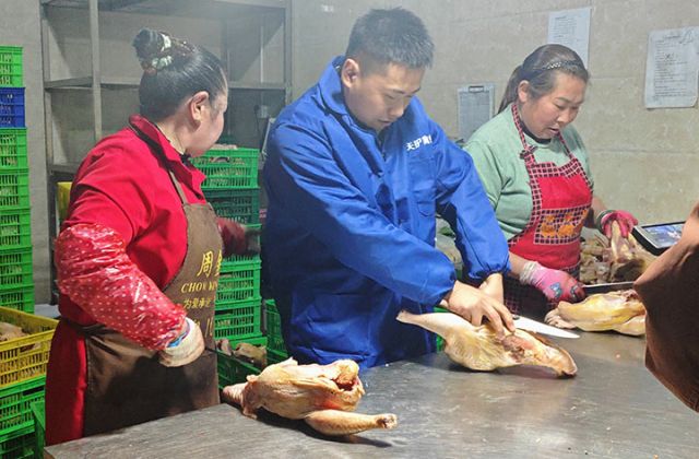 图1  唐明辉正和员工一起分解鸡肉 周倩摄.jpg