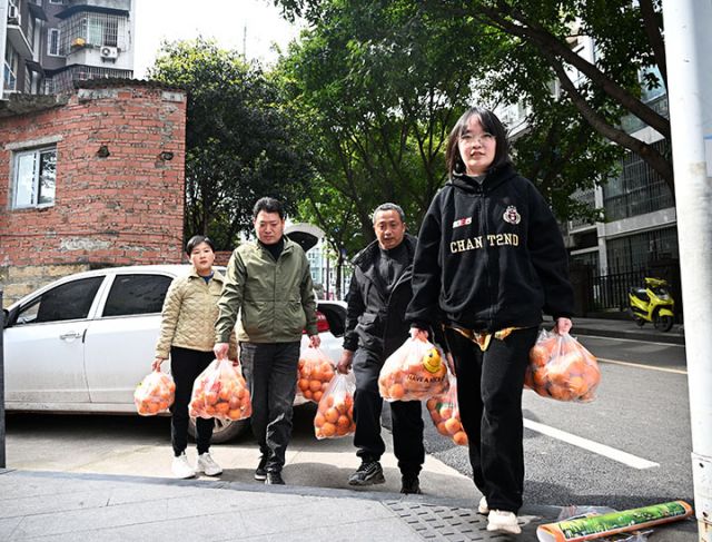 图1  3月19日，内江市东兴区东兴街道龙观社区，来自川渝毗邻的东兴区平坦镇与荣昌区清流镇促销团队成员正在转运沃柑和血橙。.JPG