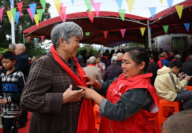 1761553693264955.jpg 图1  10月25日,四川省内江市东兴区永福镇鲤鱼塘村,志愿者为村里的老人系上暖心的红围巾。.jpg