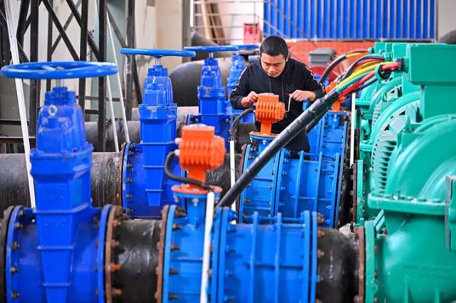 图1 在仁寿县富加加压站内，工作人员正在检查闸阀.jpg