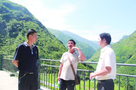 白杨乡乡长罗阿有（右一）和瓦洛村党支部书记阿苦木惹（中）向四川省民宗委经济发展处处长荣跃泽仁（左一）介绍瓦洛村产业脱贫的路子.JPG
