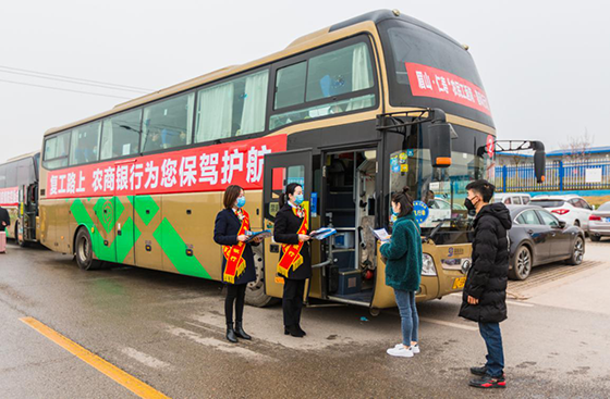 仁寿农商银行员工在农民工返岗“春风行动”专车前向农民工散发宣传资料.png