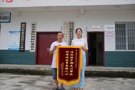 7月24日，四川沐川县武圣乡新民村脱贫户郭武兴来到村委会，将一面印有“选派好干部真心帮扶，倾情办实事爱暖人心”的锦旗送到帮扶干部林先燕手中  崔前东 摄.JPG