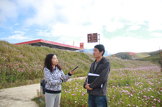 稻城县林草局副局长郭先剑（右）向记者介绍金珠湿地公园建设情况  周淼葭 摄.JPG