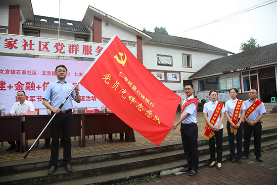 银行党支部书记、行长吴军为文宫支行党员先锋志愿队授旗.jpg