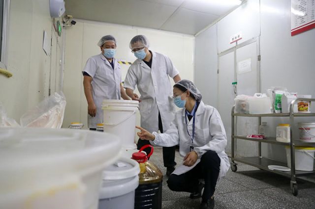 图2  前锋区市场监管局工作人员（右一）正在检查月饼生产企业原材料生产日期  前锋融媒 丁彦博 摄.jpg